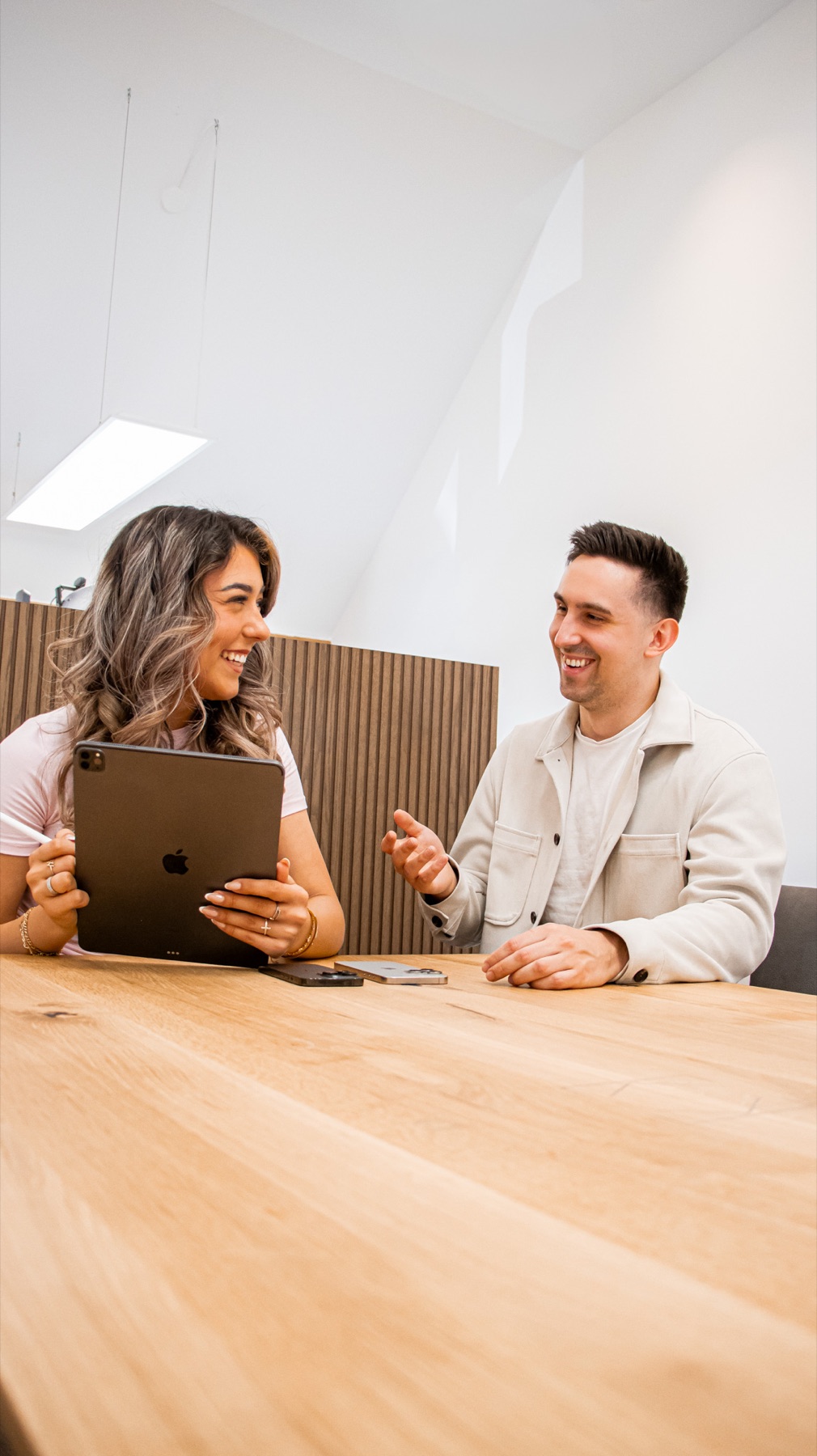 Laura und Julian von Herzly Marketing im Gespräch am Besprechungstisch
